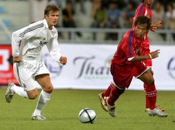 David Bekham (a la i)zquierda), lucha por el balón con el jugador tailandés Datsakorn Thonglao durante un partido amistoso disputado en el estadio Rajamangala de Bangkok,