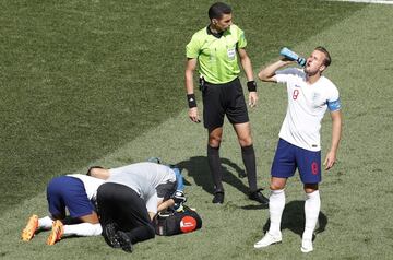 Harry Kane se refresca mientras atienden a su compañero Jesse Lingard.