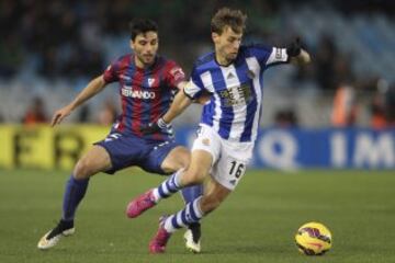 El centrocampista de la Real Sociedad Sergio Canales disputa un balón con el defensa del Eibar Eneko Bóveda.