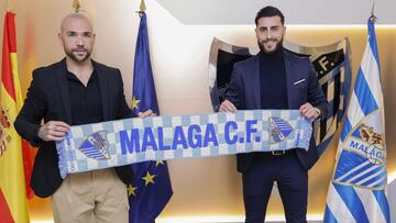 Manolo Gaspar y Luis Muñoz posan con una bufanda del Málaga.