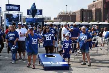 Un grupo de aficionados de los Colts posa con la defensa de su equipo (abajo en la imagen).