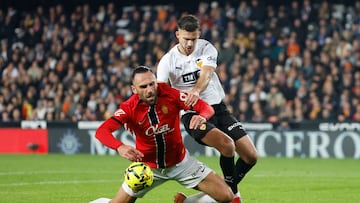 VALENCIA, 19/12/2025.- El delantero del RCD Mallorca Vedat Muriqi (i) cae tras la entrada de José Manuel Arias Copete, del Valencia CF, durante el partido de LaLiga de fútbol disputado entre el Valencia CF y el RCD Mallorca, este viernes en el estadio de Mestalla. EFE/Ana Escobar