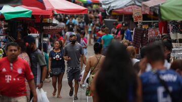 People walk along Manaus city center, Amazonas state, Brazil, on September 25, 2020. - The Brazilian city of Manaus, which was devastated by the coronavirus pandemic, may have suffered so many infections that its population now benefits from &quot;herd im