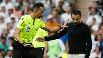 Soccer Football - LaLiga - Real Madrid v FC Barcelona - Santiago Bernabeu, Madrid, Spain - October 16, 2022 Referee Jose Maria Sanchez Martinez talks to FC Barcelona coach Xavi REUTERS/Susana Vera