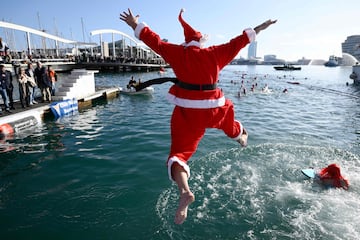 Un participante vestido de Santa Claus salta al agua en el puerto de Barcelona.