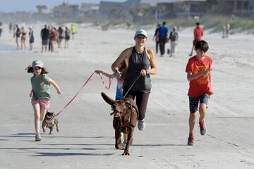 Una familia saca a pasear a su perro en la Jacksonville Beach, Florida.