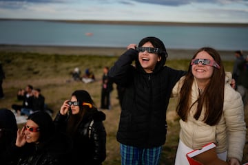 Personas observan un eclipse solar anular en Puerto San Julián, Argentina.