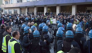 Riot police with Napoli fans at the arrival of Juventus football team bus before the Italian Serie A football match SSC Napoli vs Juventus FC at San Paolo Stadium on March 30, 2014.