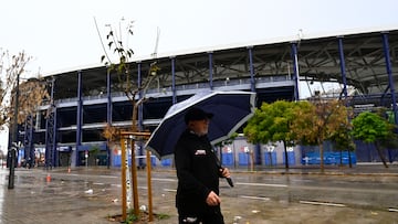A man walks with an umbrella outside the Ciutat de Valencia stadium after the Spanish league football match between Levante UD and Villarreal CF was suspended due to severe weather warning of torrential rains in Valencia on December 14, 2025. (Photo by Jose Jordan / AFP) PARTIDO SUSPENDIDO POR LLUVIA TEMPORAL