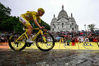 El ciclista esloveno Tadej Pogacar, del equipo UAE Team Emirates - XRG, luciendo el maillot amarillo de líder de la general, pasa en bicicleta por la Basílica del Sacré-Coeur.