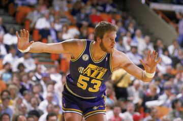 Mark Eaton pasó once a?os en Utah Jazz, desde su selección en el draft de 1982 hasta su retirada en 1993. Lo jugó casi todo, 875 de los 902 partidos posibles de temporada regular, para perjuicio de sus rivales. Porque el californiano era un gigante de 224 centímetros que hizo del tapón su santo y se?a: tiene el récord de tapones en una campa?a con 456 en 1984-85, curso en el que promedió 5,56 por encuentro. En total, en su carrera puso 3.064 tapones. Fue dos veces Defensor del A?o, el primer pívot en ganar un premio después dominado por los jugadores de su posición: 1985 y 1989. En la segunda de esas temporadas fue all star y en la primera sus medias alcanzaron 9,7 puntos, 11,3 rebotes y 5,6 tapones. Falleció a los 64 a?os.