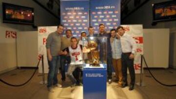 Un grupo de aficionados posa junto al trofeo de la NBA.