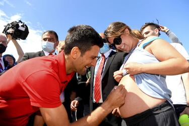 Cualquier sitio es bueno con tal de tener el autógrafo de alguno de tus ídolos, incluso el vientre de una mujer embarazada. Novak Djokovic firma en la tripa de Vanessa Kezerle durante una sesión de fotos en Brighton Beach (Melbourne) un día después de su victoria sobre Daniil Medvedev en la final del Abierto de Australia. 
