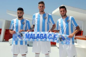 Los nuevos jugadores del Málaga: Adnane Tighadouini , Duje Cop y Raul Albentosa posan con la bufanda del club en su presentación.