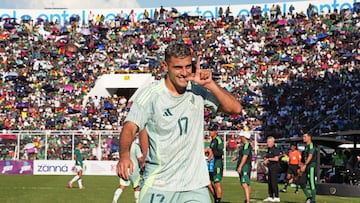 Imagen de Germán Berterame con camiseta verde claro señalándose el oído tras marcar un gol en Bolivia.
