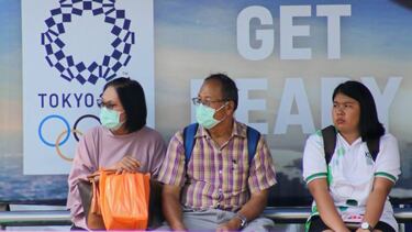 Ciudadanos tailandeses ante un cartel de los Juegos Olímpicos de Tokio en Bangkok