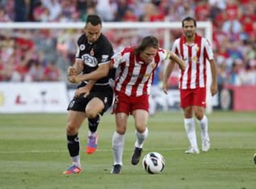 El centrocampista del Almería, Miguel Ángel Corona, lucha el balón con Eloi Amagat, del Girona, durante el partido de vuelta de la eliminatoria de ascenso a Primera División que los dos equipos juegan, esta tarde, en el estadio de los Juegos Mediterráneos.