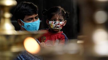 A man along with his daughter visits a temple reopened as the government eased a nationwide lockdown imposed as a preventive measure against the Covid-19 coronavirus, in Chennai on September 1, 2020. (Photo by Arun SANKAR / AFP)