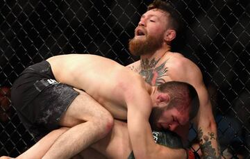 Khabib Nurmagomedov presiona a Conor McGregor contra la jaula durante su combate en el UFC 229.