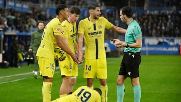 Villarreal's Uruguayan defender #15 Santiago Mourino, Villarreal's Spanish defender #06 Pau Navarro and Villarreal's Spanish midfielder #14 Santi Comesana speaks with Spanish referee Alejandro Quintero as Villarreal's Ivorian forward #19 Nicolas Pepe lies on the ground during the Spanish League football match between Deportivo Alaves and Villarreal CF at Mendizorroza Stadium in Vitoria on March 13, 2026. (Photo by ANDER GILLENEA / AFP)