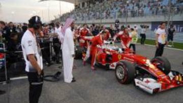 Alonso mira el Ferrari de Vettel antes del GP de Bahrein.