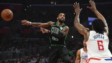 Kyrie Irving, base de los Boston Celtics, realiza un pase ante DeAndre Jordan, p&iacute;vot de Los Angeles Clippers.