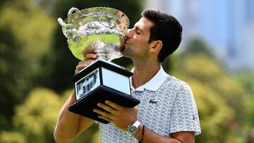 Novak Djokovic besa el trofeo Norman Brookes como campe&oacute;n del Open de Australia 2020.