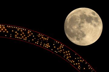 La luna se eleva tras un cartel antiguo en la cima de un edificio de apartamentos en el centro de la ciudad, el mi¨¦rcoles 16 de octubre de 2024, en Kansas City.