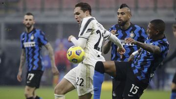 Juventus' Federico Chiesa, center, is challenged by Inter Milan's Ashley Young during a Serie A soccer match between Inter Milan and Juventus at the San Siro stadium in Milan, Italy, Sunday, Jan. 17, 2021. (AP Photo/Luca Bruno)