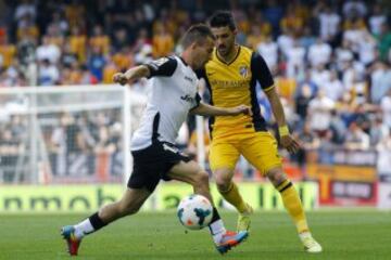 El defensa portugués del Valencia João Pereira (i) con el balón ante el delantero del Atlético de Madrid David Villa (d) en el partido de la trigésima quinta jornada de liga de Primera División, disputado esta tarde en el estadio de Mestalla. 