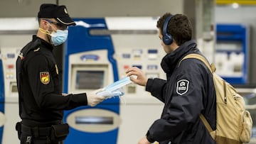 MADRID, SPAIN - APRIL 13: A Spanish police officer distributes face masks at the Intercambiador de Moncloa on April 13, 2020 in Madrid, Spain. More than 17,000 people are reported to have died in Spain due to the coronavirus (COVID-19) outbreak, although