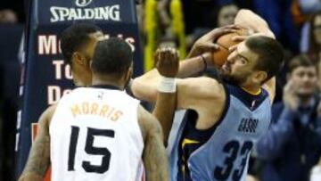 Marc Gasol lucha por el balón con Markieff Morris (i) y Marcus Morris (c).
