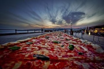 Fotografía facilitada hoy, 19 de mayo de 2016 de una pizza napolitana de dos kilómetros de largo, elaborada para batir el récord del mundo, y colocada a lo largo del paseo marítimo en Nápoles (Italia) ayer. EFE/Ciro Fusco