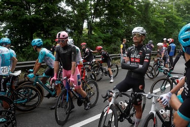 Los ciclistas esperan después de que la carrera se detuviera debido a varios accidentes durante la sexta etapa.