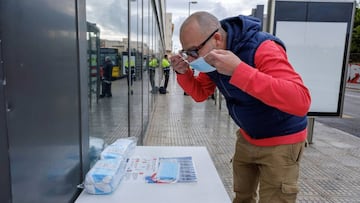 Un trabajador procede a ponerse una mascarilla siguiendo las instrucciones de la Organización Mundial de la Salud.