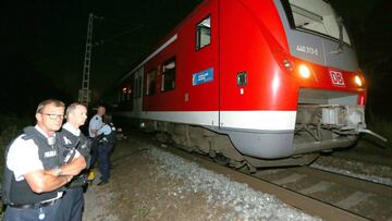 FPT016. WUERZBURG (ALEMANIA), 18/07/2016.- Polic&iacute;as inspeccionan junto a un tren regional hoy, lunes 18 de julio de 2016, en WuErzburg (Alemania). Informaciones indican que un hombre supuestamente con un hacha hiri&oacute; a m&uacute;ltiples pasajeros en un tren regional en Wuerzburg. EFE/Karl-Josef Hildenbrand