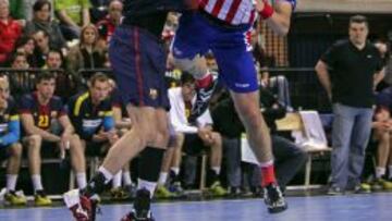El lateral izquierdo del Atl&eacute;tico de Madrid Mariusz Jurkiewicz lanza ante la oposici&oacute;n de un jugador del barcelonista Viran Morros.