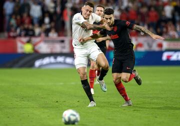El jugador del Sevilla, Lucas Ocampos, lucha con el jugador rojiblanco, Mario Hermoso, un balón. 