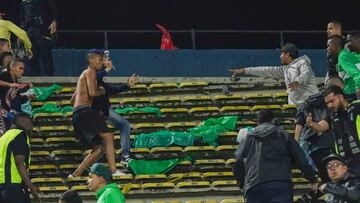 Fans of Atletico Nacional and Junior fight on the stands during the Colombian league football match between Atletico Nacional and Junior in Medellin, Colombia, on August 26, 2024. About 20 fans and a policeman were injured in a knife fight at a Medellin stadium on Thursday night, forcing the suspension of a Colombian league match, the mayor's office said. (Photo by STRINGER / AFP)