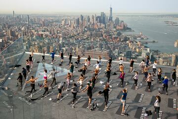 Un grupo de personas hace yoga en la azotea de un edificio de Manhattan (Nueva York). Como ocurre con muchos tipos de ejercicios al aire libre, esta pr¨¢ctica cogi¨® gran demanda durante la pandemia del coronavirus, y no se ha pasado de moda, sino m¨¢s bien al contrario: hay semanas de lista de espera para asistir a las clases.