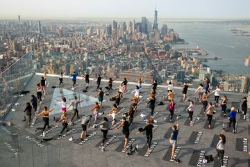 Un grupo de personas hace yoga en la azotea de un edificio de Manhattan (Nueva York). Como ocurre con muchos tipos de ejercicios al aire libre, esta práctica cogió gran demanda durante la pandemia del coronavirus, y no se ha pasado de moda, sino más bien al contrario: hay semanas de lista de espera para asistir a las clases.