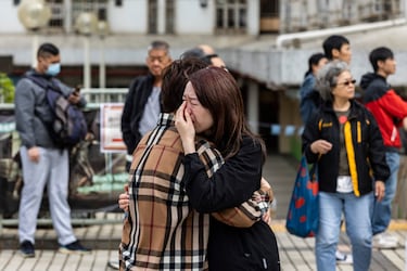 Una mujer llora cerca de edificios residenciales.