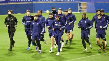 Los jugadores del Real Zaragoza trotan sobre el césped de La Romareda en el entrenamiento de esta tarde.