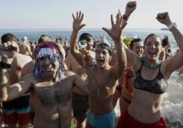 Decenas de ciudadanos participaron este mediodía en el tradicional primer baño del año en la playa de Sant Sebastià del barcelonés barrio de la Barceloneta.