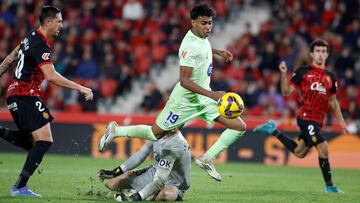 Barcelona's Spanish forward #19 Lamine Yamal challenges Real Mallorca’s Spanish goalkeeper #13 Leo Roman during the Spanish league football match between RCD Mallorca and FC Barcelona at the Mallorca Son Moix stadium in Palma de Mallorca on December 3, 2024. (Photo by JAIME REINA / AFP)