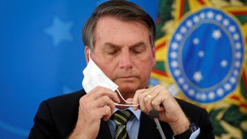 FILE PHOTO: Brazil&#039;s President Jair Bolsonaro adjusts his protective face mask during a press statement to announce federal judiciary measures to curb the spread of the coronavirus disease (COVID-19) in Brasilia, Brazil March 18, 2020. Picture taken 