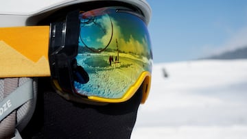 A reflection in ski goggles shows people in a snow-covered field in Gulmarg, a ski resort and one of the main tourist attractions in the Kashmir region, January 7, 2025. REUTERS/Sharafat Ali