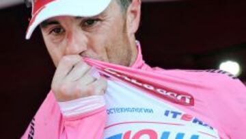 El ciclista italiano Luca Paolini, del Katusha, besa en el podio el jersey rosa de líder.