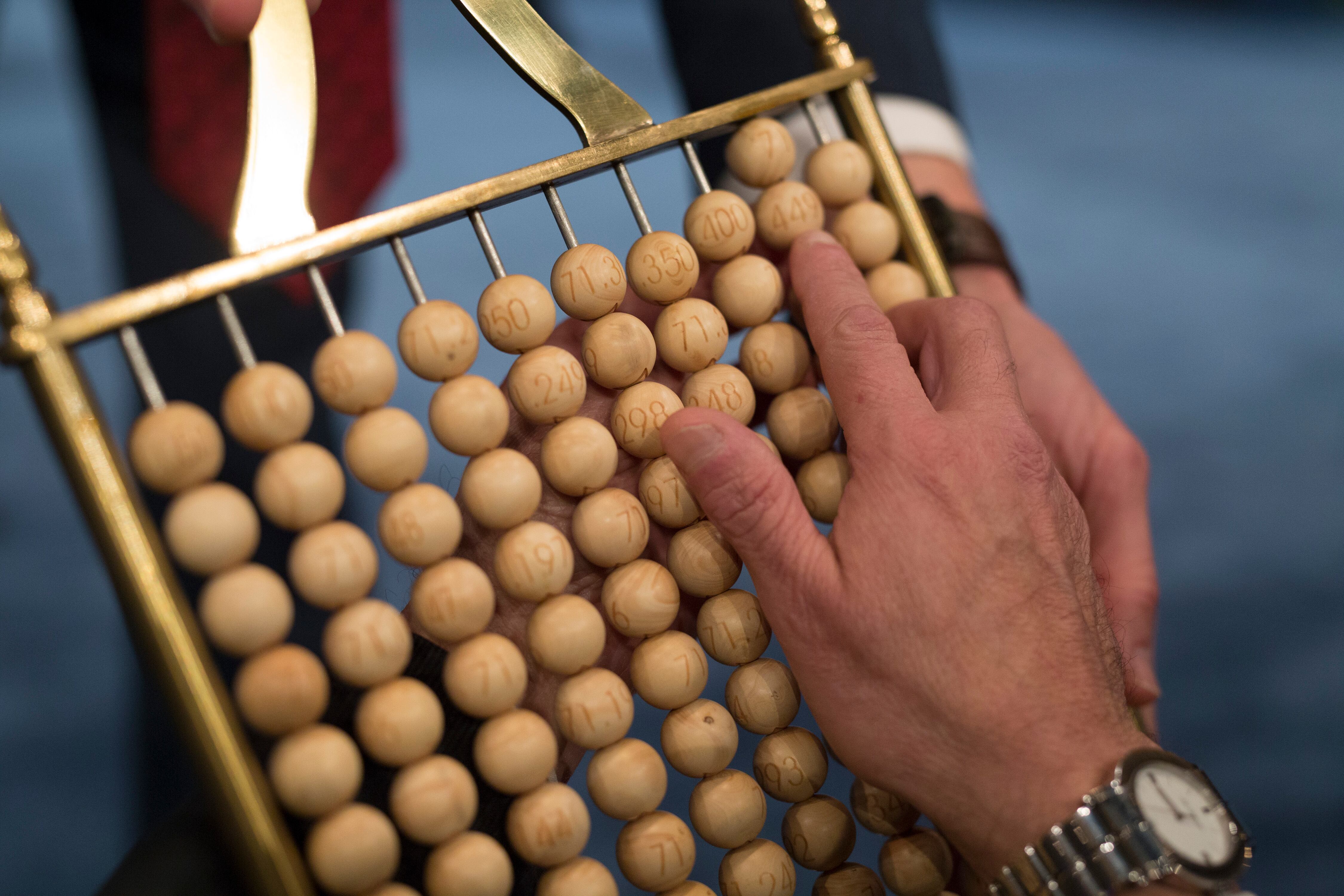 MADRID, SPAIN - DECEMBER 22:  Officials check a ball bearing with the lottery ticket number of an spectator during the draw of Spain's Christmas lottery named 'El Gordo' (Fat One) at the Teatro Real on December 22, 2017 in Madrid, Spain. The winning number wins a total of 4 million euros for the top prize to be shared between ten ticket holders.  (Photo by Pablo Blazquez Dominguez/Getty Images) LOTERIA NAVIDAD SORTEO