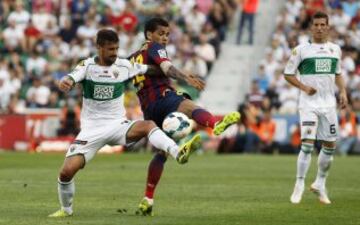 El defensa brasileño del FC Barcelona Dani Alves lucha un balón con el centrocampista del Elche Javi Márquez.